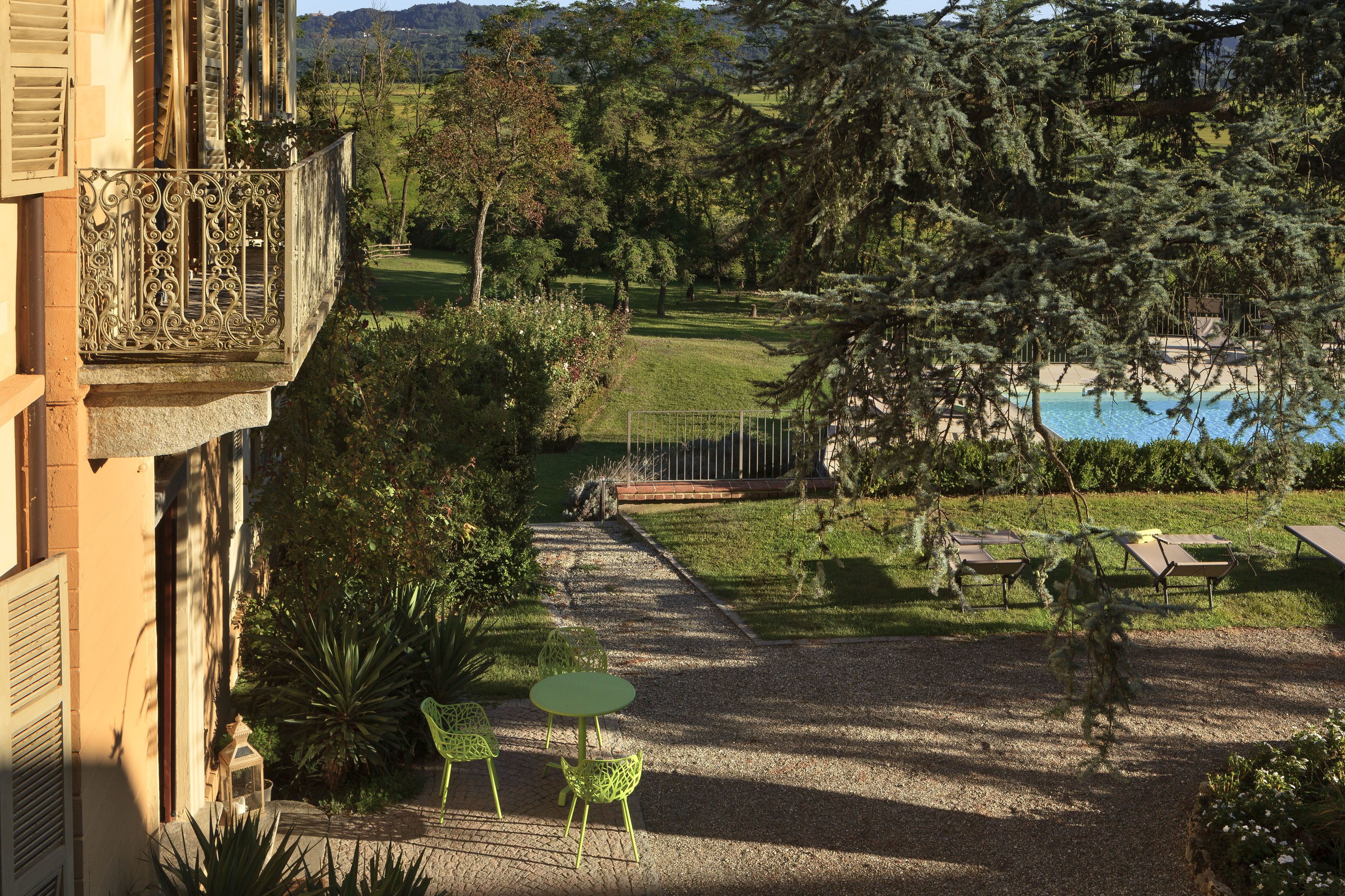 A courtyard with a pool, outdoor seating, and lush greenery.