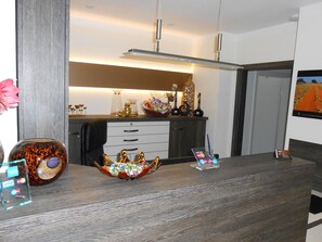 Una cocina moderna con encimera de madera, un florero con objetos de colores y un cuenco decorativo.
