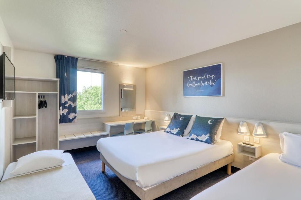 A hotel room with a bed, bedside tables, a desk, a wardrobe, and a window with curtains.