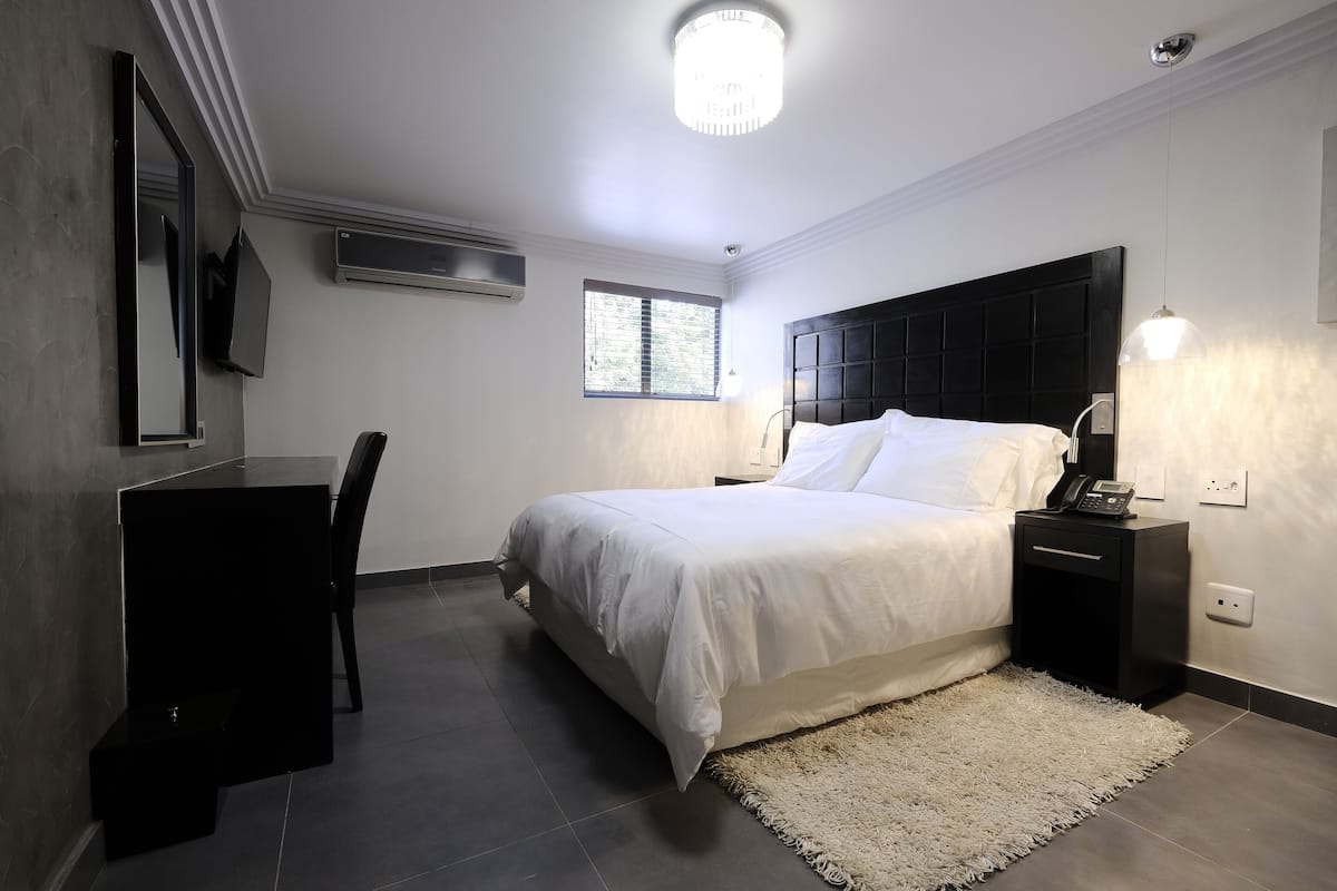 Une chambre moderne avec un grand lit, un bureau et une chaise.