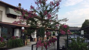 A residential area with a house featuring a balcony with pink flowering plants. - Da Carla Trattoria con Locanda (Gambolo)