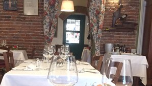 A dining table set with wine glasses, a bowl of fruit, and cutlery. - Da Carla Trattoria con Locanda (Gambolo)