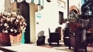 An outdoor seating area with wicker chairs and a potted plant. - Da Carla Trattoria con Locanda (Gambolo)