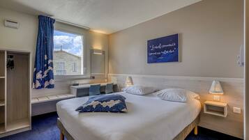 Quarto de hotel com cama, mesas de cabeceira, janela com vista, um banco embutido e uma obra de arte na parede.