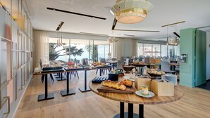 A spacious dining area with a long table set for breakfast, featuring bread, pastries, and condiments. - Hotel du Leman (Jongny)
