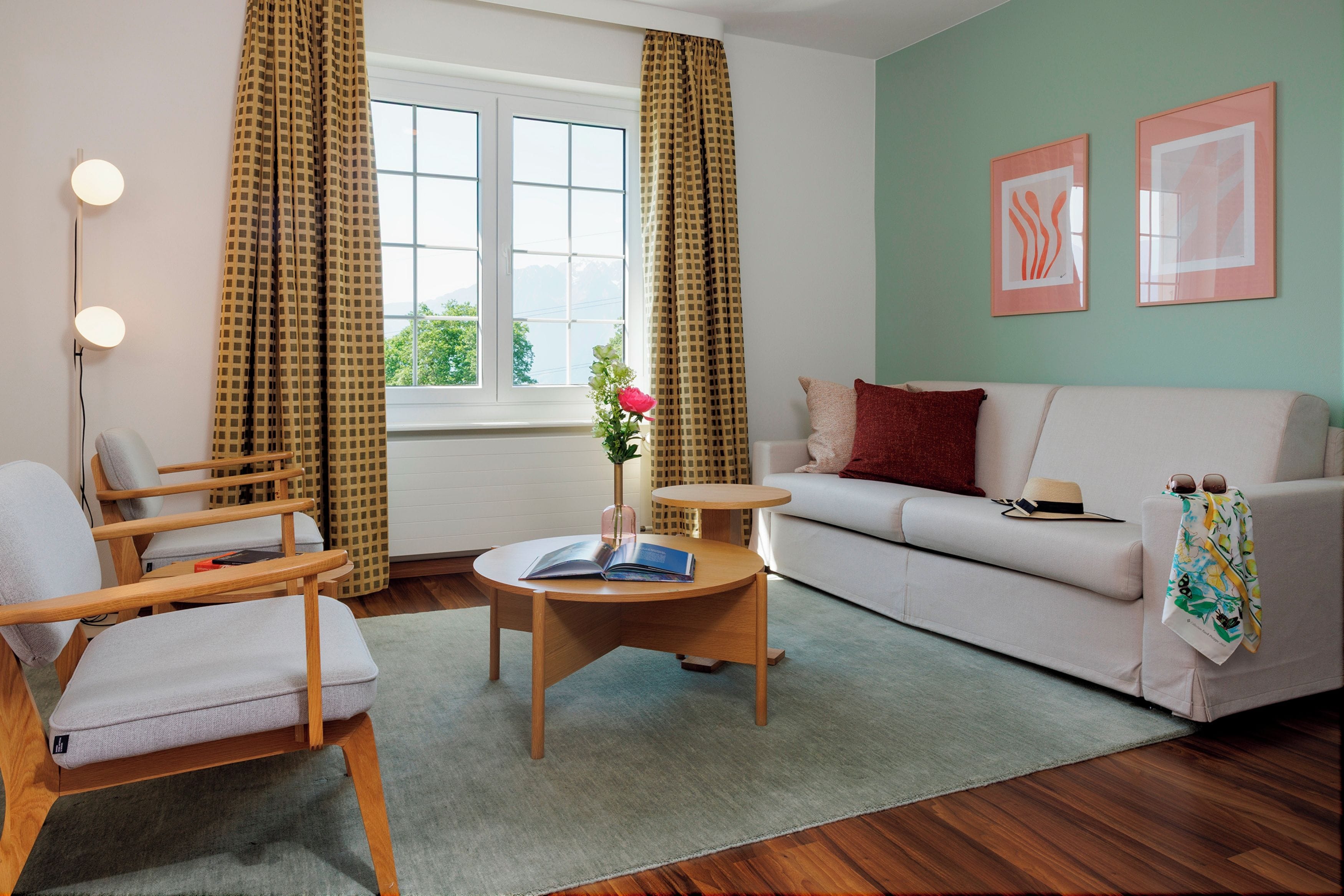 A modern living room with a sofa, armchair, and a small round table.