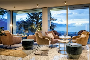 Un interior moderno con ventanas amplias, asientos cómodos y vistas a montañas.