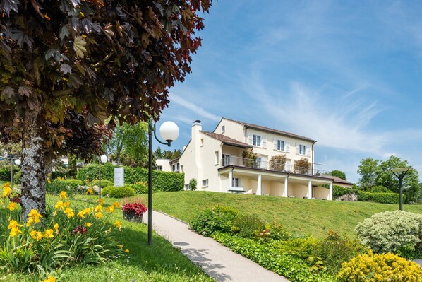 A large, multi-story building with a white facade and a balcony on the upper floor. - Hotel du Leman (Jongny)