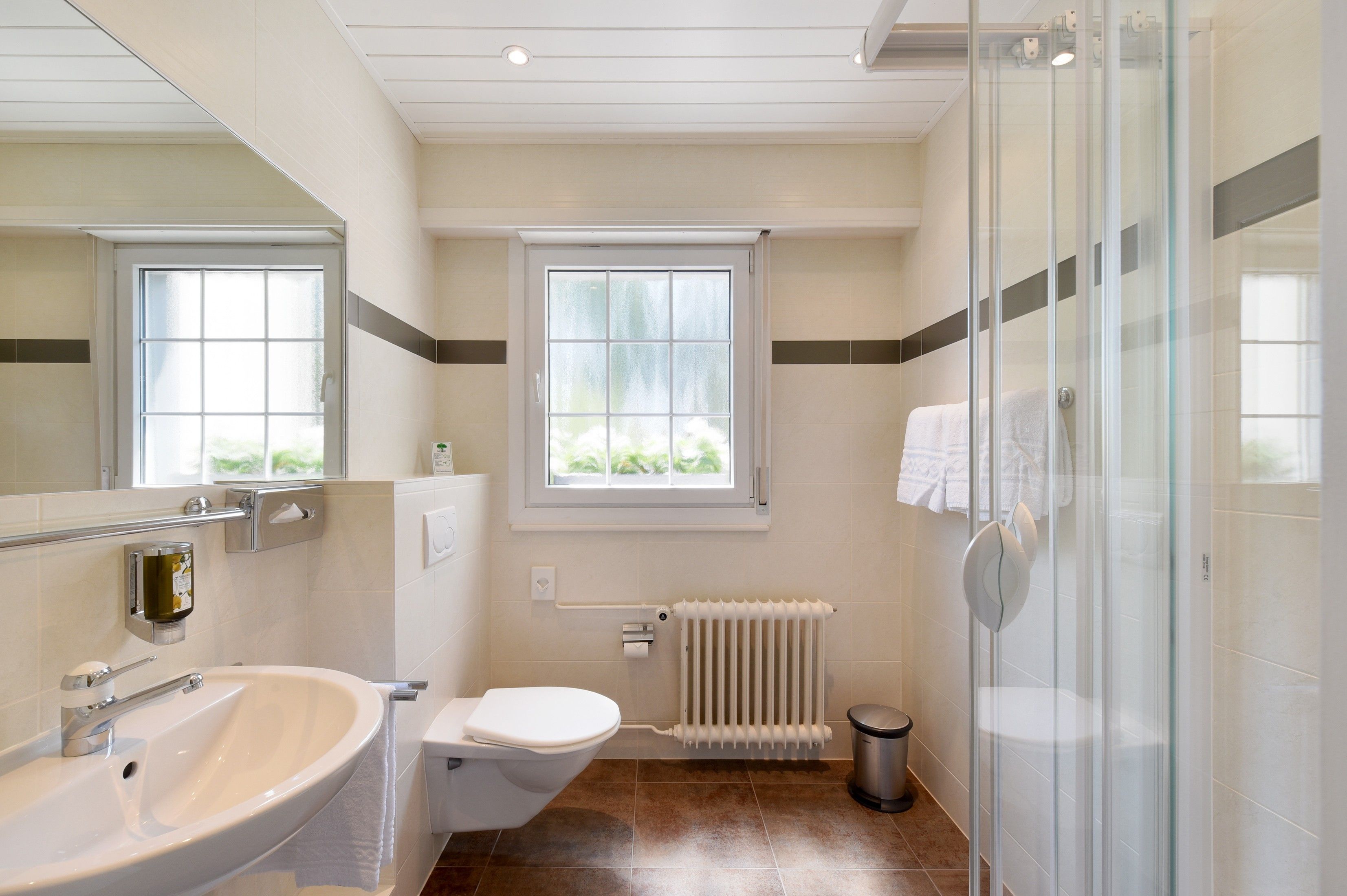 Ein modernes Badezimmer mit Waschbecken, Toilette und Duschbereich.
