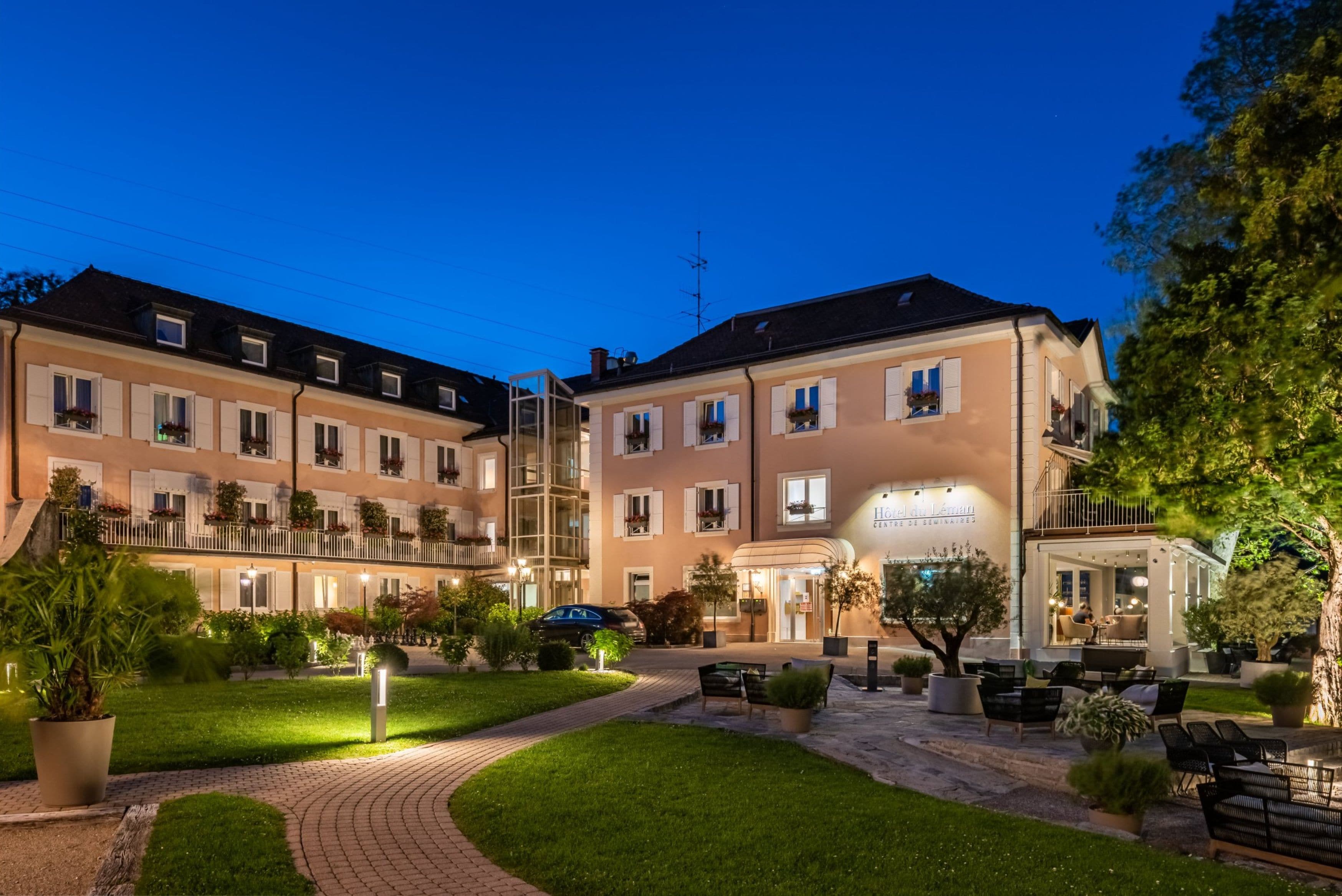 Ein Hotel mit Innenhof, Außenbereich und einem gut beleuchteten Eingang.