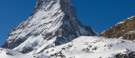 A snow-covered mountain peak with a clear blue sky.