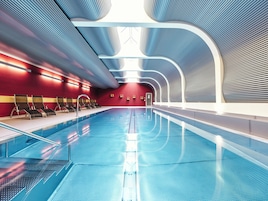 Una piscina techada, sillones reclinables de piscina