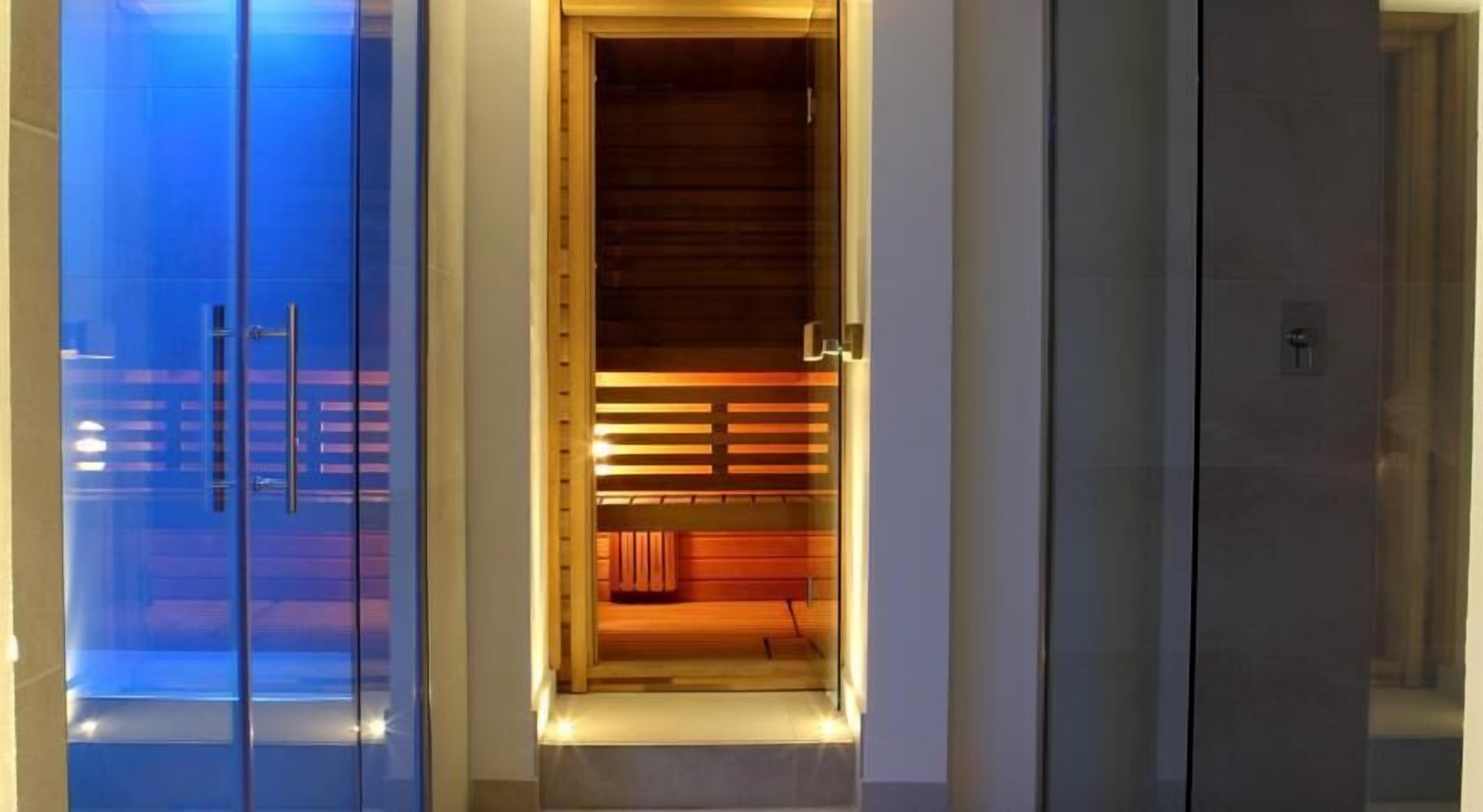 Entrada de un hotel moderno con puerta de cristal y detalles del interior de madera a la vista.