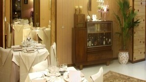 Un coin repas agrémenté de lambris en bois, d’un buffet et d’une plante en pot.