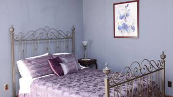 Ein Schlafzimmer mit einem Bett, einem Nachttisch und einem gerahmten Bild an der Wand.