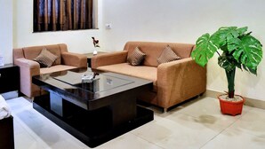 Un salon moderne avec deux canapés, une table basse et une plante en pot.
