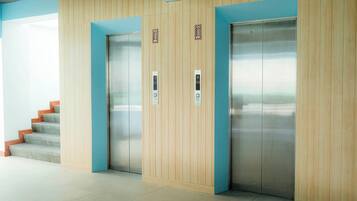 A modern elevator area with wooden paneling and a blue accent wall.