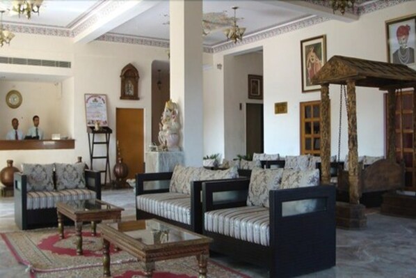 A traditional living room with sofas, a coffee table, and a decorative wooden structure.