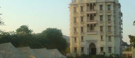 A multi-story building with balconies and a sign reading "Satyam Palace".