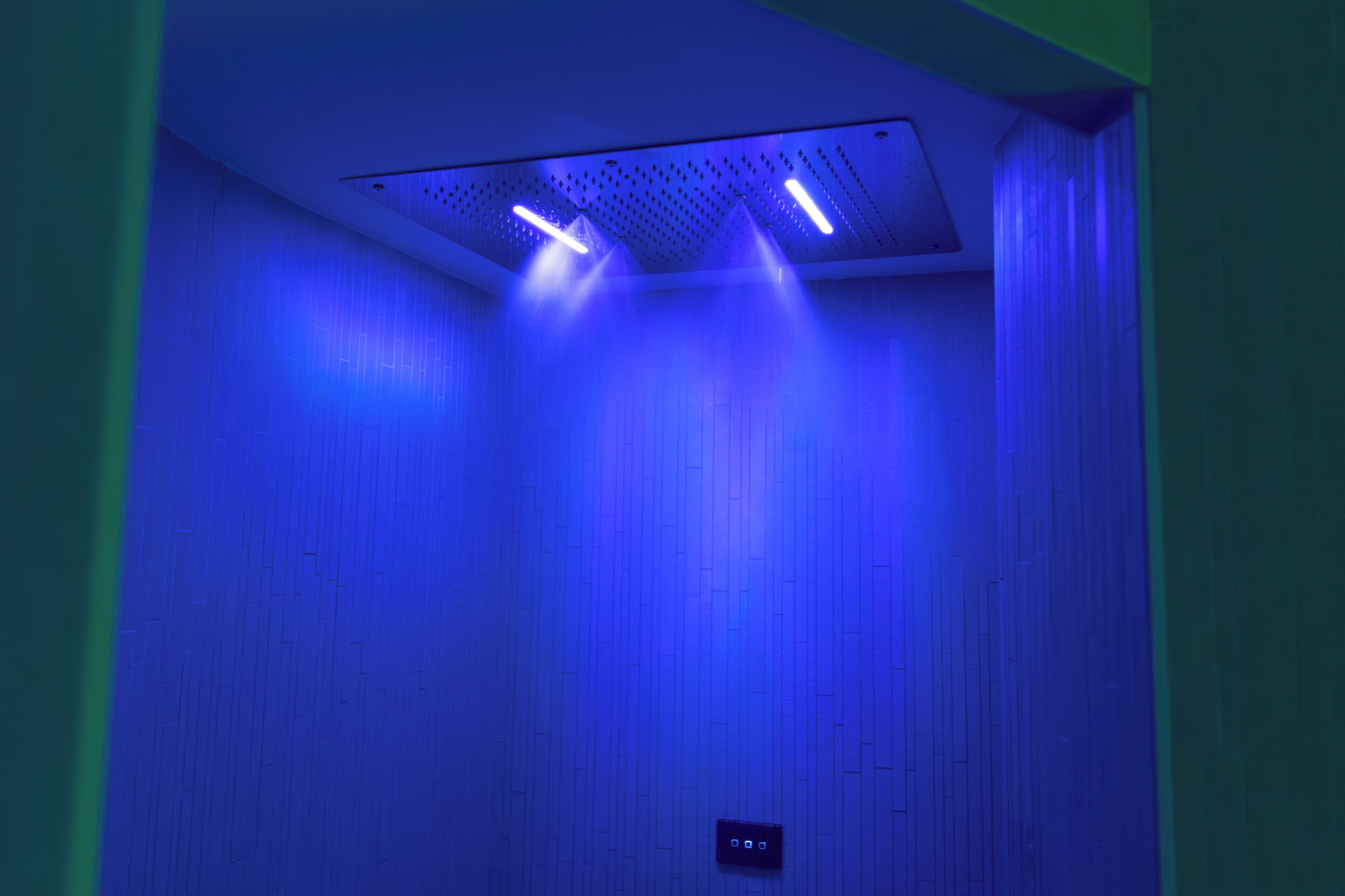 A room with a ceiling light fixture emitting blue light.