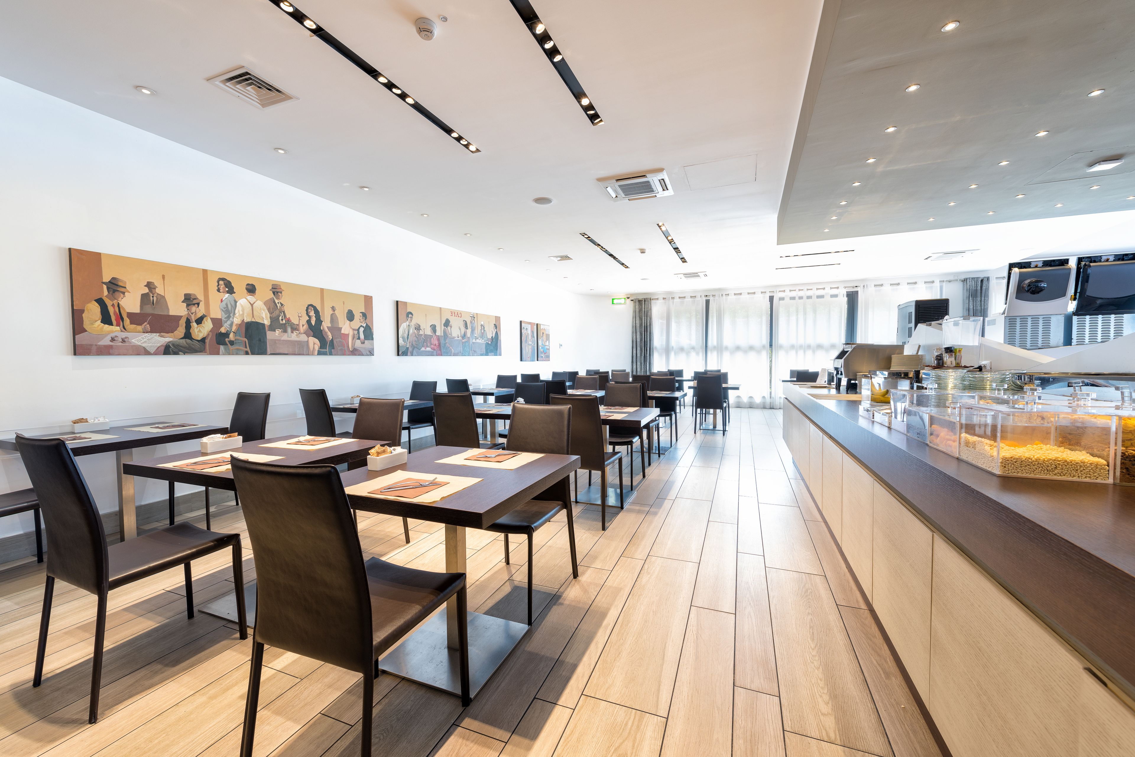 A modern conference room with long tables, chairs, and a buffet counter.