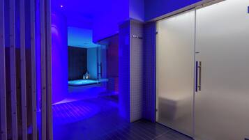 A modern bathroom with a shower, a toilet, and a sink.
