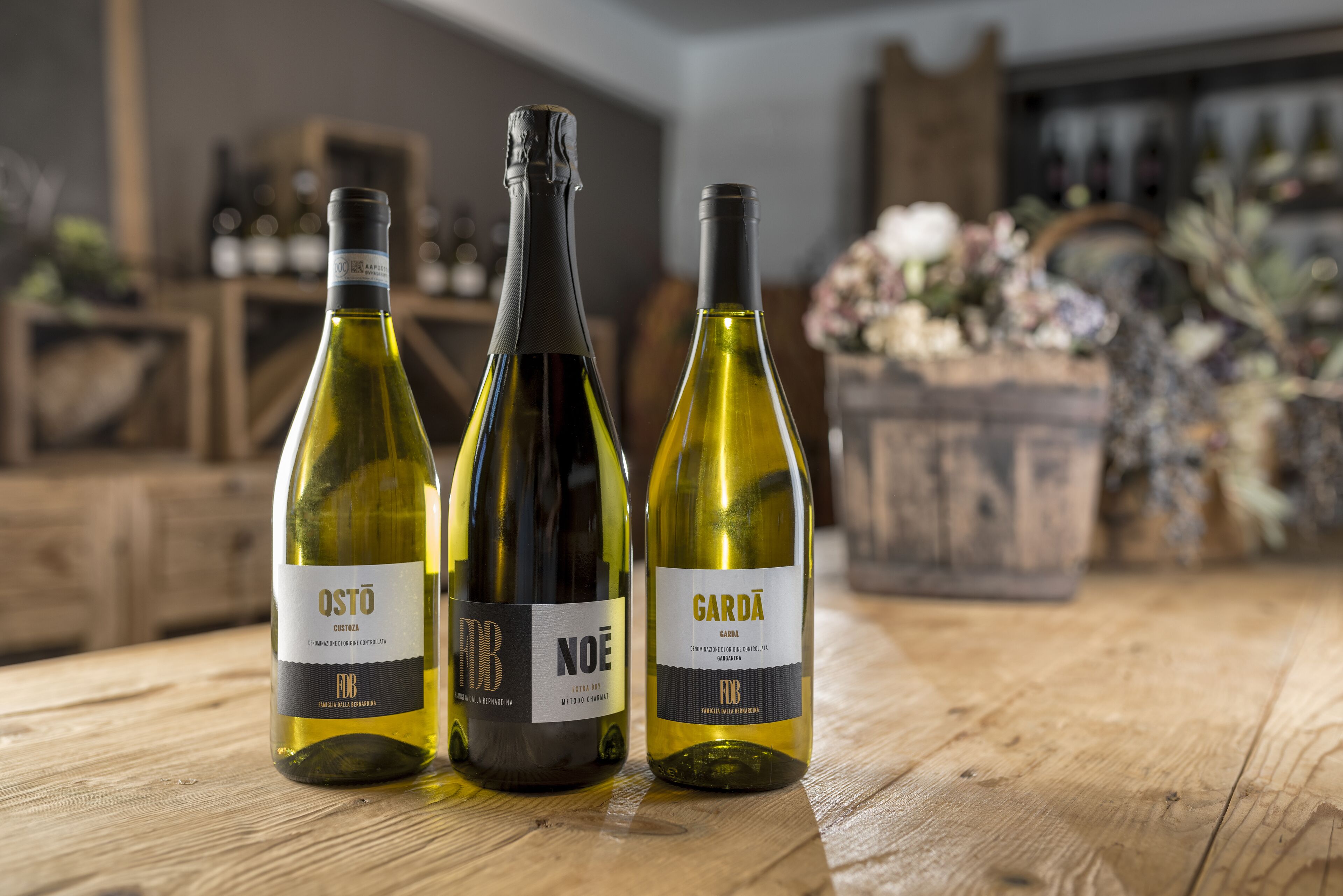 Tres botellas de vino sobre una mesa de madera.