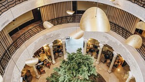 Atrio a più livelli con un'area salotto centrale circondata da colonne, con un'ampia pianta e diversi livelli di posti a sedere.