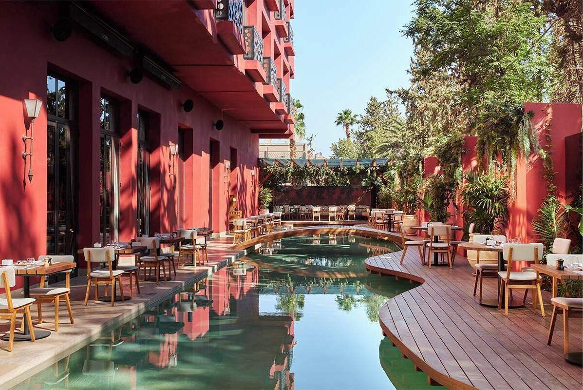 Área de piscina com mobiliário externo e piscina refletora.