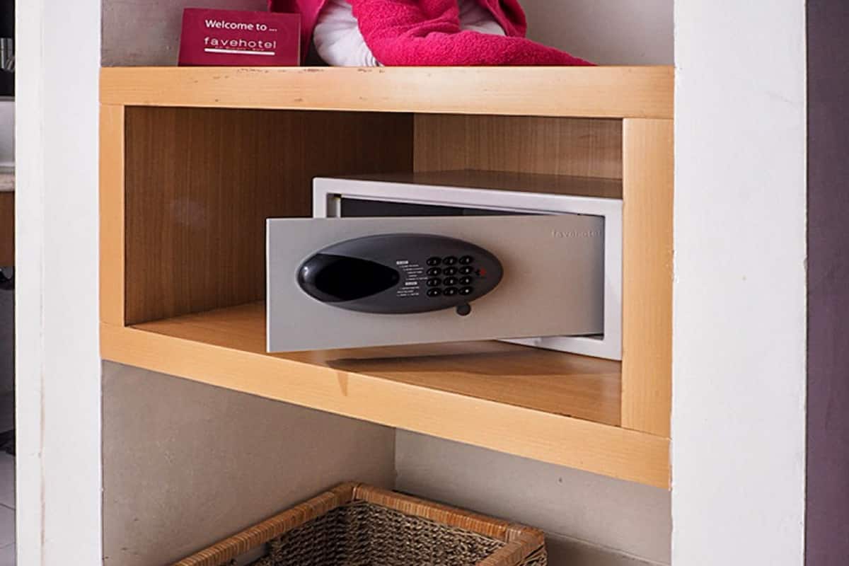 A wooden shelf with a plush toy, a sign, a remote control, a wicker basket, and a pair of slippers.