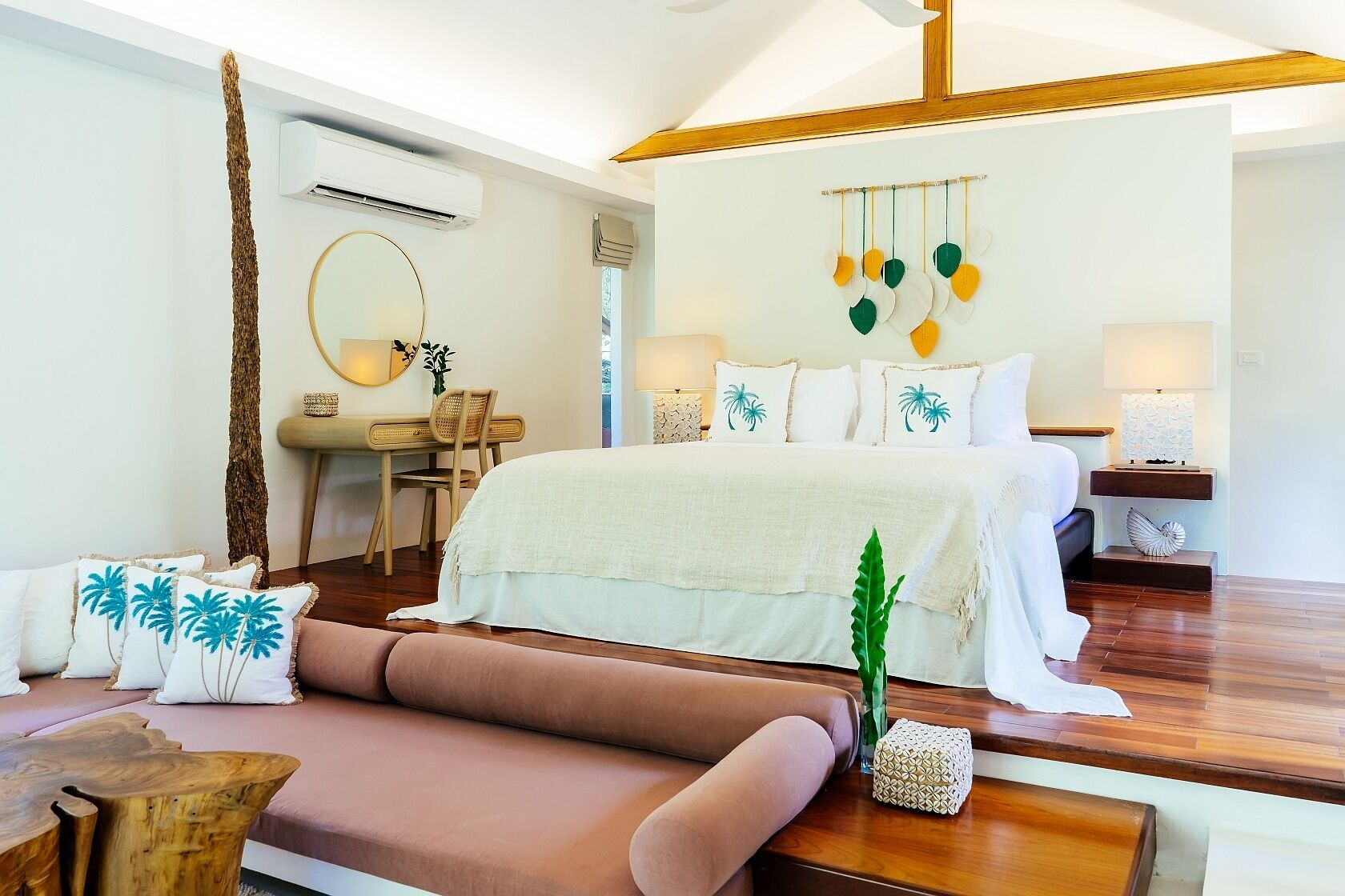 A bedroom with a bed, a desk, a chair, and a sofa.