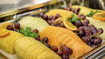 A buffet with various fruits and grapes.