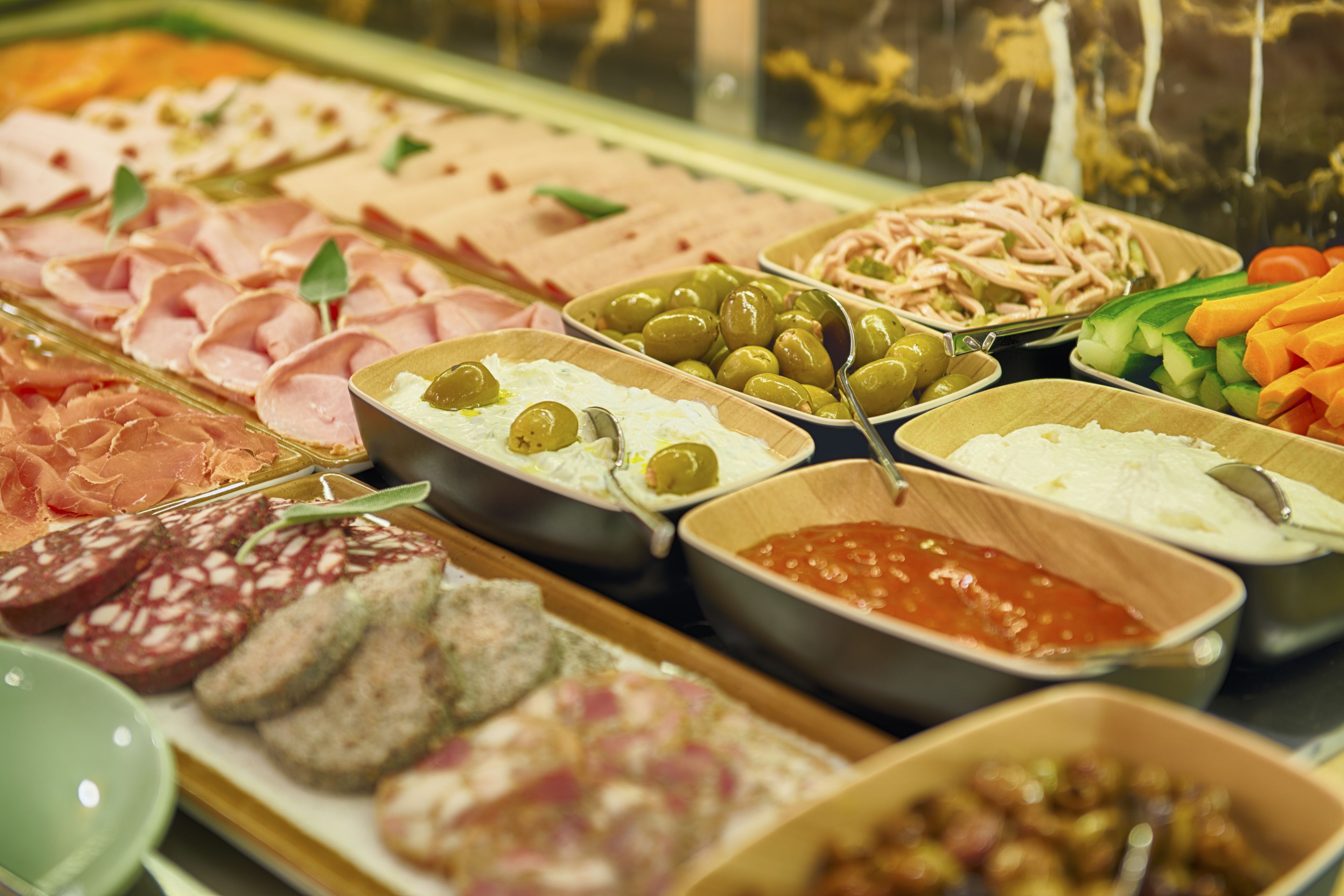 Verschiedene Speisen werden in einem Buffet angerichtet.