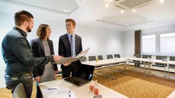 A conference room with a long table, chairs, and a laptop.