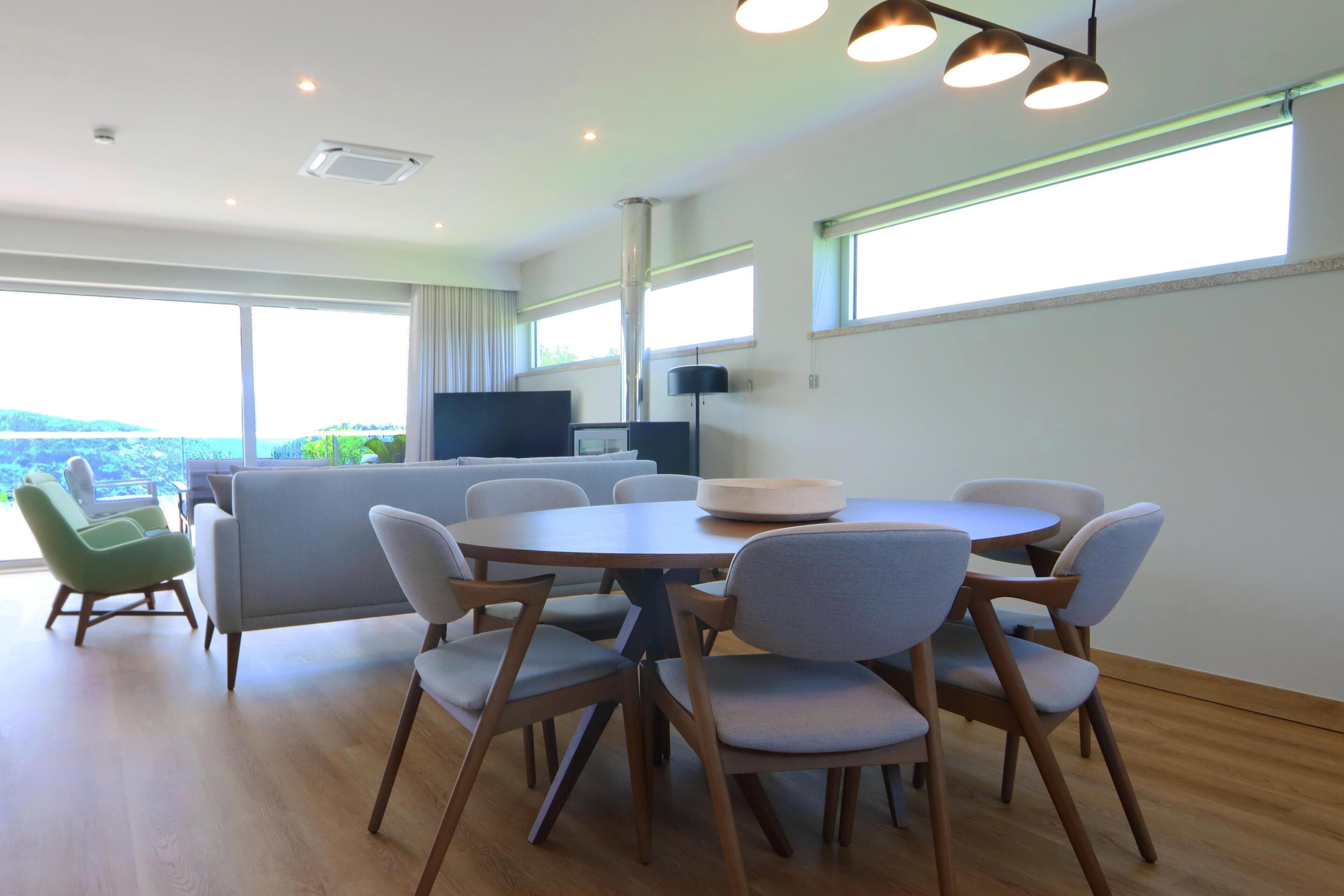 Un espace repas moderne avec une table ronde et des chaises, un canapé et un téléviseur.