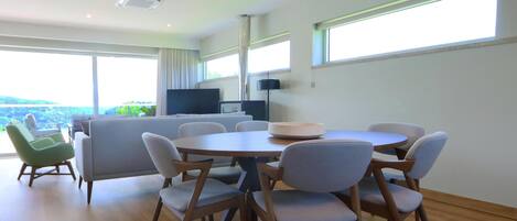 Un espace repas moderne avec une table ronde et des chaises, un canapé et un téléviseur.