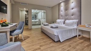 Moderni hotellihuone, jossa on suuri sänky, työpöytä ja tuoli.