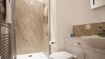 A modern bathroom with a shower, toilet, and sink.