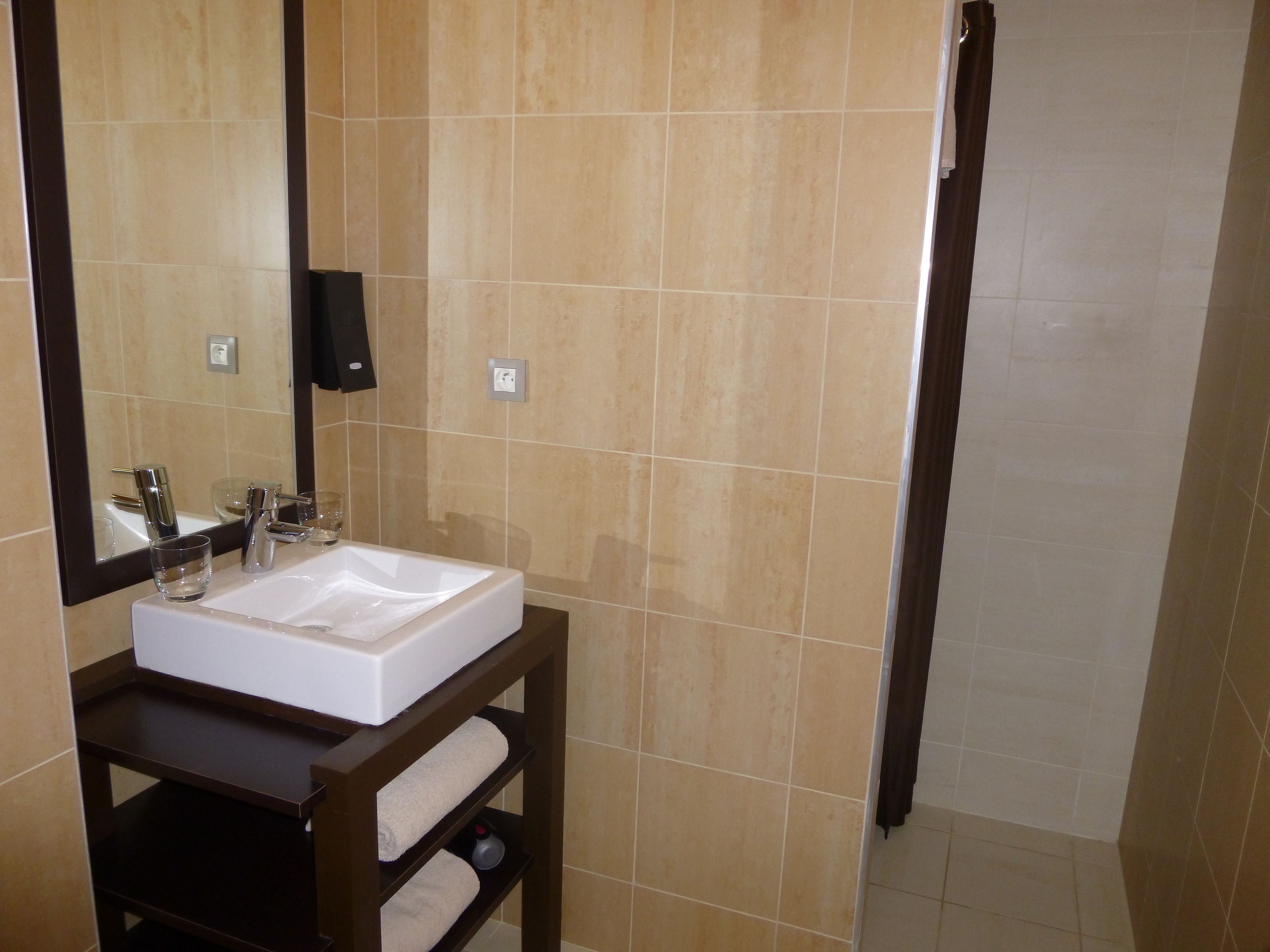 A bathroom with a white sink, a mirror, and a towel rack.