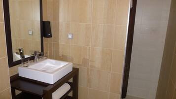 A bathroom with a white sink, a mirror, and a towel rack.