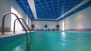 An indoor swimming pool with clear blue water, a tiled ceiling, and a few potted plants. - Domaine de Bel Air (Cerans-Foulletourte)
