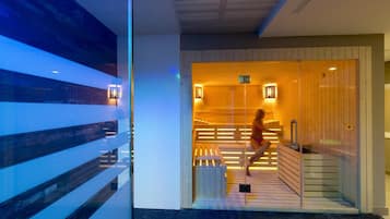 Una sauna con bancos de madera y entrada de vidrio.