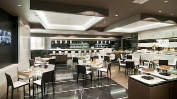 Un restaurante moderno con barra, suelo de mármol y mobiliario contemporáneo.