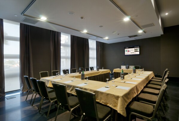 A conference room with a long table, chairs, and a screen on the wall. - Parco dei Principi Hotel Congress & Spa (Bari)