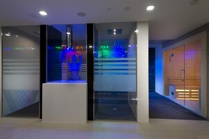 A modern interior with glass partitions, a central display, and a sauna area.