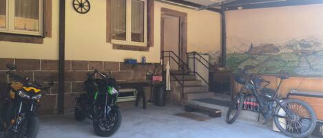 Un área de estacionamiento techada con dos motocicletas y una bicicleta.