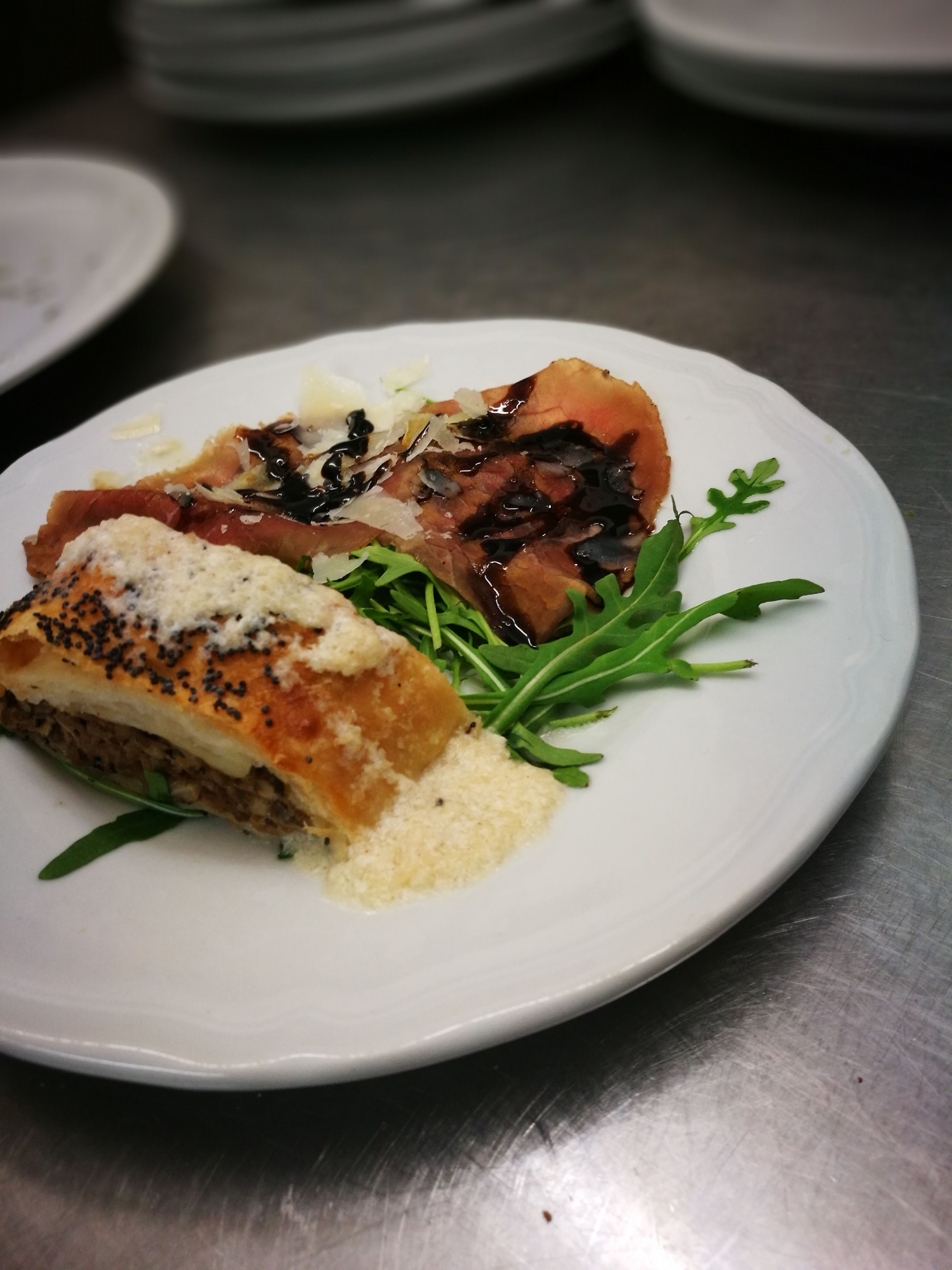 Un plato con carne, vegetales verdes y una salsa cremosa.