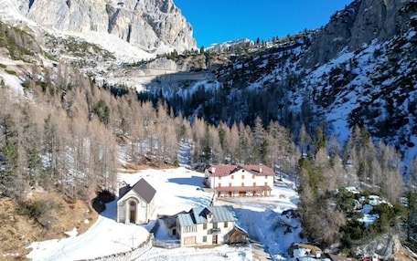 A mountain village with snow-covered ground, a church, and houses with red roofs.
