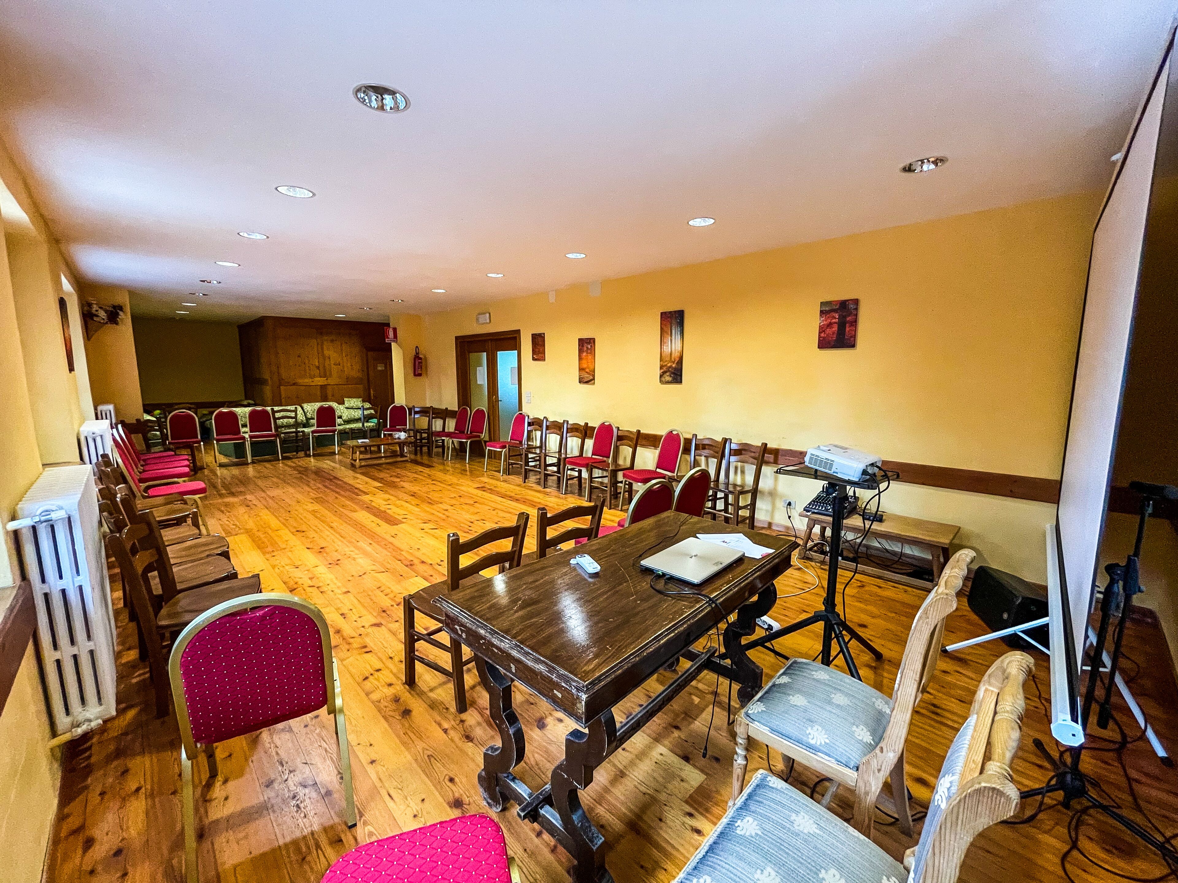 A conference room with wooden tables and chairs, a projector, and a whiteboard.