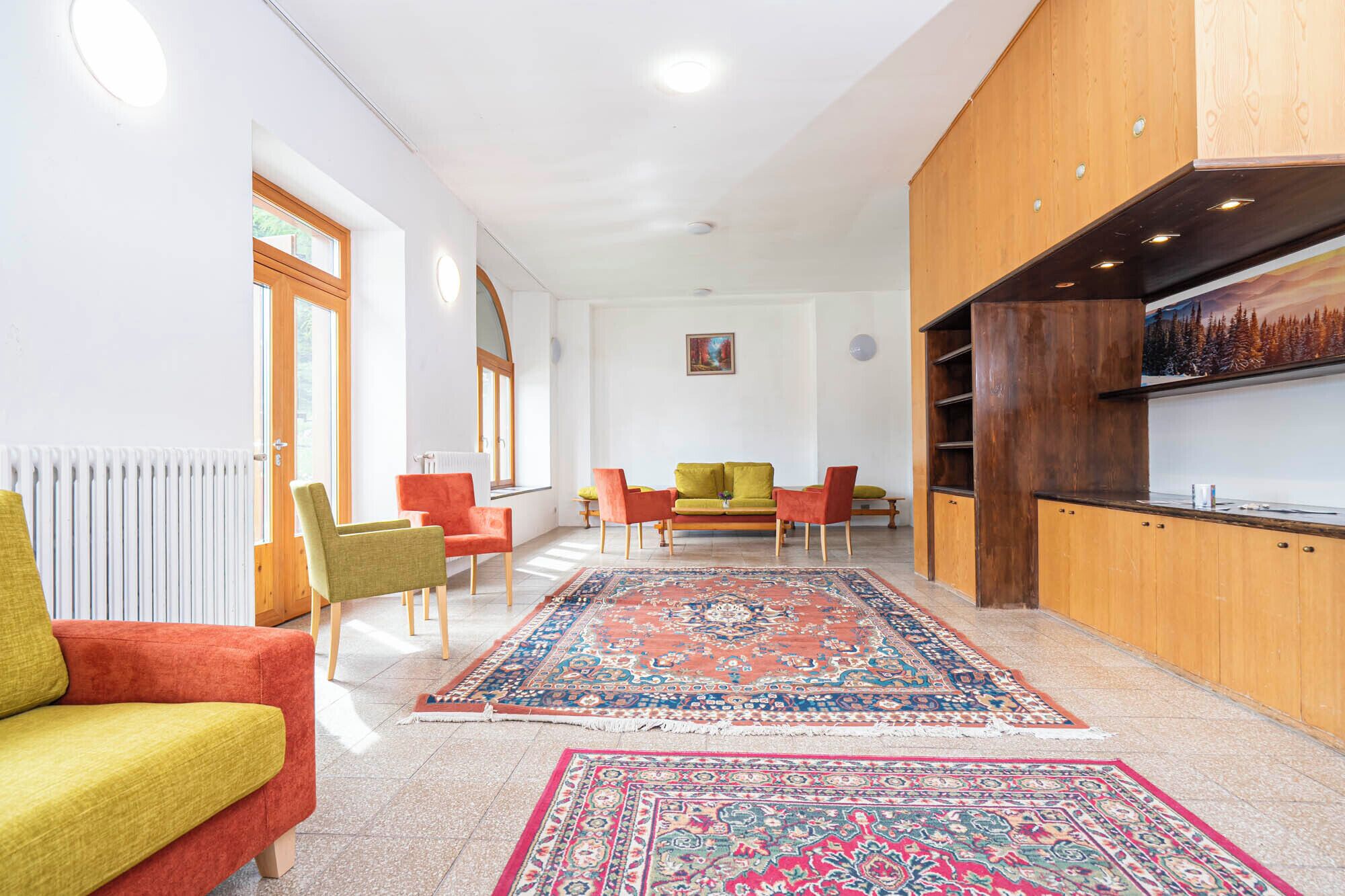 A modern living room with a sofa, chairs, a coffee table, and a rug.